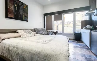 a bedroom with a bed and a kitchen with a window at Cozy Home In Miramas With Outdoor Swimming Pool in Miramas