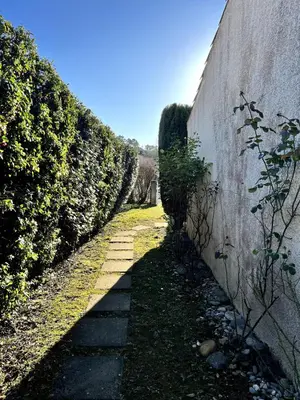 a stone path next to a wall with bushes at Charming house, Lubéron, near golf and wineries in Pierrevert