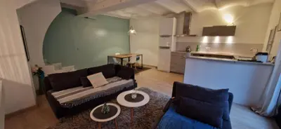 a living room with a couch and a kitchen at Charming village house in Éguilles