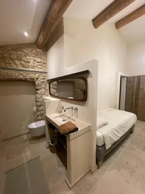 a bathroom with a sink and a bed in a room at Le Jas à Goult in Goult