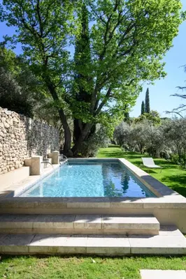 a swimming pool in a garden with stairs and trees at Le Hameau des Sources Lourmarin Luberon in Lourmarin