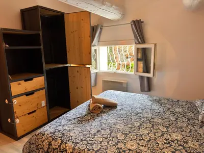 a bedroom with a bed and a dresser and a window at Le Breizh'Aix - Joli duplex au cœur du centre ville d'Aix-en-Provence avec jardin in Aix-en-Provence
