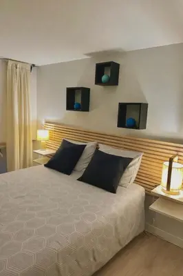 a bedroom with a bed with two monitors on the wall at Perle Aix en Provence centre ville in Aix-en-Provence