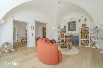 a living room with an orange chair and a fireplace at Domaine Arterra I Parc privé, Piscine & Tennis in Lauris