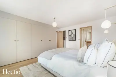 a white bedroom with a large bed and white cabinets at Domaine Arterra I Parc privé, Piscine & Tennis in Lauris