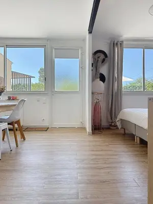 a bedroom with a bed and a desk and windows at Studio en Provence in Cheval-Blanc