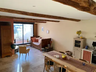 a living room with a table and a couch at Casa Poli, maison de village avec terrasse in Eyguières