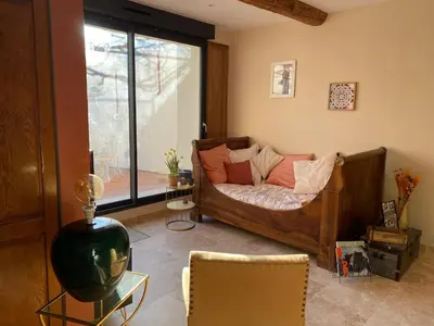 a bedroom with a bed and a glass window at Casa Poli, maison de village avec terrasse in Eyguières