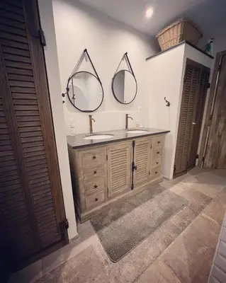 a bathroom with a sink and two mirrors on the wall at La propriété de Nans in Grans
