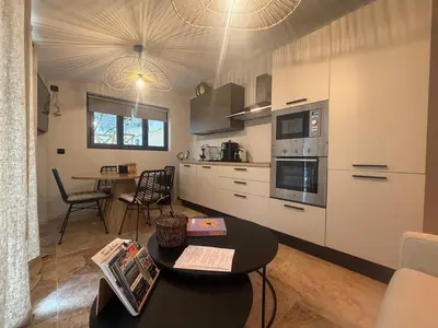 a kitchen with a table and a dining room at Charmant appartement T2 cosy avec piscine in Mollégès