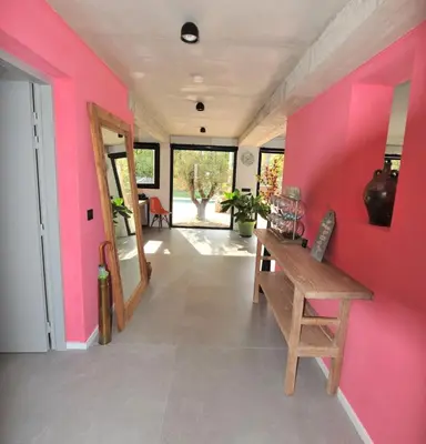 a room with a pink wall and a wooden bench at Villa 5 étoiles, 6 personnes in LʼIsle-sur-la-Sorgue