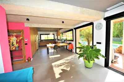 a kitchen and living room with a table and a plant at Villa 5 étoiles, 6 personnes in LʼIsle-sur-la-Sorgue