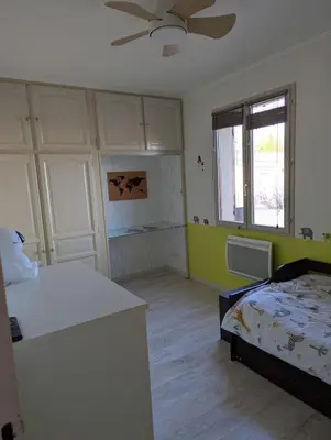 a bedroom with a bed and a ceiling fan at Maison 3 pièces avec jardin et terrasse in La Fare-les-Oliviers