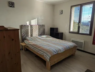 a bedroom with a bed and a dresser in it at Maison 3 pièces avec jardin et terrasse in La Fare-les-Oliviers