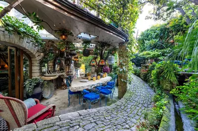 a stone patio with a table and blue chairs at Signature Home Pool & Panoramic Terrace in Goult