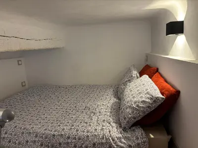 a small bedroom with a bed and a lamp at Appartement 1 chambre, 2 lits, vue Cathédrale in Aix-en-Provence