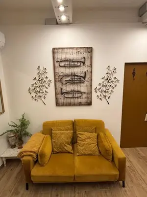 a yellow couch in a room with a painting on the wall at Appartement Turandot, 1 chambre, près du Cours Mirabeau in Aix-en-Provence