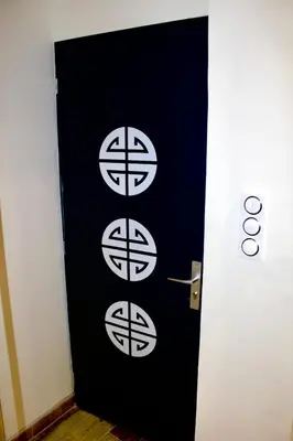 a black door with white circles on it at Appartement Lotus Rouge, 2 chambres, proche Mairie in Aix-en-Provence