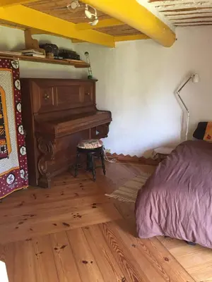 a bedroom with a piano and a bed in it at Belle villa avec piscine, belle vue, calme absolu in Apt