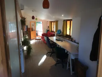 a room with a desk and chairs and a living room at Belle villa avec piscine, belle vue, calme absolu in Apt