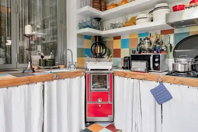 a kitchen with a red cabinet in the middle at Romantic Provence Pool & Mill View in Goult
