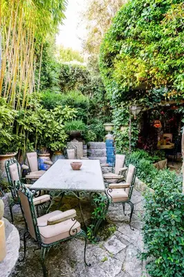 a table and chairs sitting in a garden at Romantic Provence Pool & Mill View in Goult