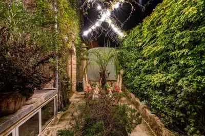 a garden with plants and lights on a wall at Romantic Provence Pool & Mill View in Goult