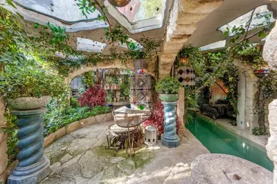 an indoor garden with a swimming pool and plants at Romantic Provence Pool & Mill View in Goult