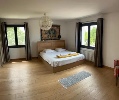 a bedroom with a bed and a chandelier at mas de la bergerie in Cavaillon