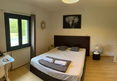 a bedroom with a bed with two pillows and an elephant at mas de la bergerie in Cavaillon