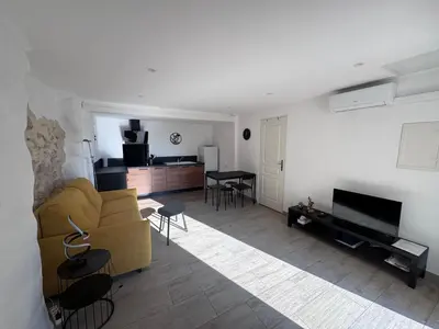 a living room with a couch and a table at Studio Rénové de Charme en Provence in Caumont-sur-Durance