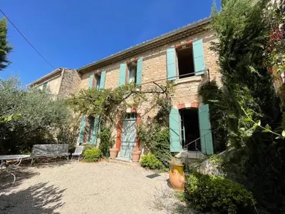 a brick house with a bench in front of it at Pierre Jacques' House in Caromb