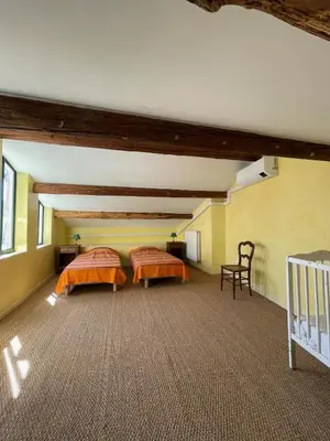 two beds in a large room with yellow walls at Pierre Jacques' House in Caromb