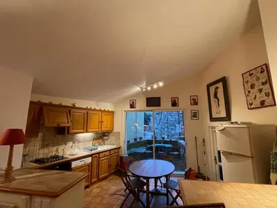 a kitchen with wooden cabinets and a table in it at Pierre Jacques' House in Caromb