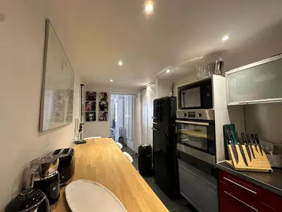 a kitchen with a wooden counter top and a black refrigerator at Chez Anne - Appartement cosy avec mezzanine au cœur du centre historique d'Aix-en-Provence in Aix-en-Provence
