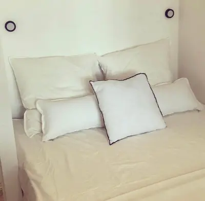 a white bed with four pillows on it at Superbe mas provençal avec piscine dans le Luberon in Lagnes