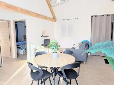 a living room with a blue couch and a table at À l'ombre du pin in Entraigues-sur-la-Sorgue
