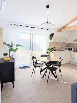 a living room with a table and a couch at À l'ombre du pin in Entraigues-sur-la-Sorgue