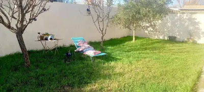 a blue chair sitting in the grass next to a table at Le Colibri Très belle maison près d'Avignon in Carpentras