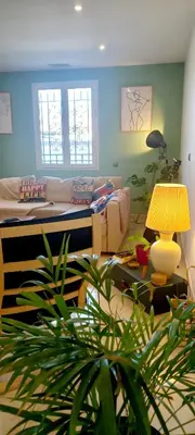 a living room with a bed and a potted plant at Le Colibri Très belle maison près d'Avignon in Carpentras