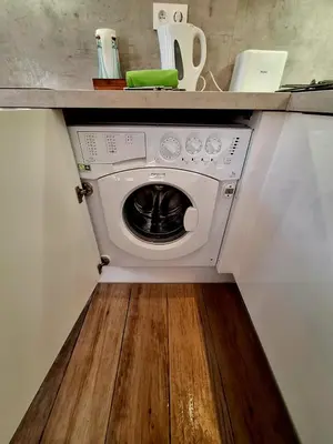 a washer and dryer under a counter in a kitchen at Grand studio dans le centre historique in Aix-en-Provence