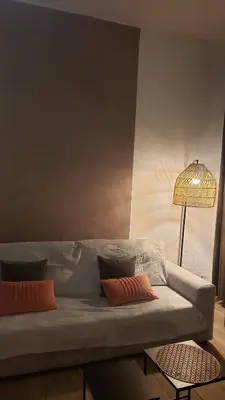 a living room with a couch and a lamp at Grand studio dans le centre historique in Aix-en-Provence