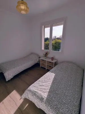 a bedroom with two beds and a window at Villa Papillon in Monteux