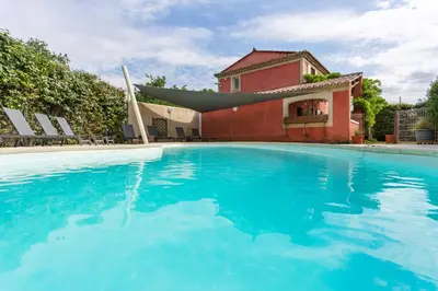 a swimming pool in front of a house at Les gites de Bel-Air en Luberon in Les Taillades