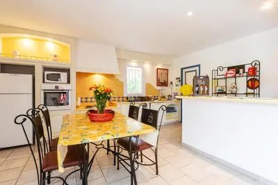 a kitchen with a table with chairs and a counter at Les gites de Bel-Air en Luberon in Les Taillades