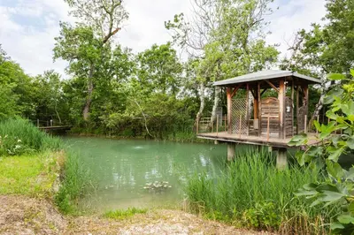 a gazebo on a bridge over a river at Les gites de Bel-Air en Luberon in Les Taillades