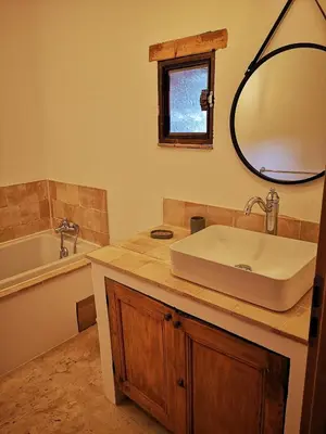 a bathroom with a sink and a tub and a mirror at Petit mas en Provence in Cornillon-Confoux