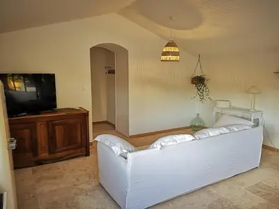 a living room with a white couch and a tv at Petit mas en Provence in Cornillon-Confoux