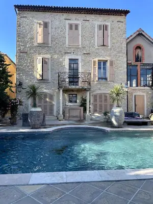 a large house with a swimming pool in front of it at La Maison du village in Pierrevert