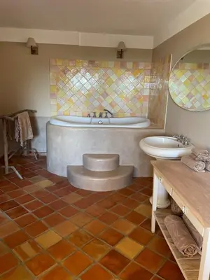 a bathroom with a tub and a toilet and a sink at La Maison du village in Pierrevert